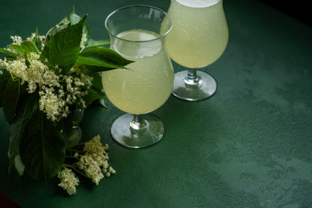Carbonated elderflower drink. Flower summer kvass in glasses. Floral green background copy spaceの写真素材