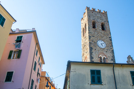 Bell ringer in Monterosso, Cinque Terre. Clock on the church tower. Colorful houses buildings Italian village narrow street old architecture Italy.の写真素材