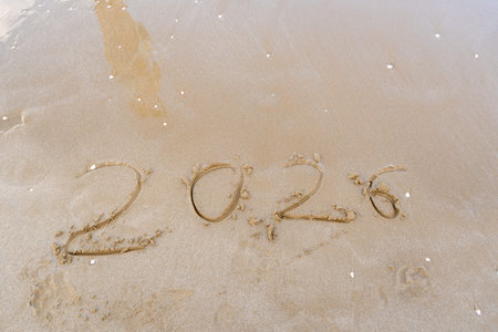 2026 numbers written in the sand. Copy space background