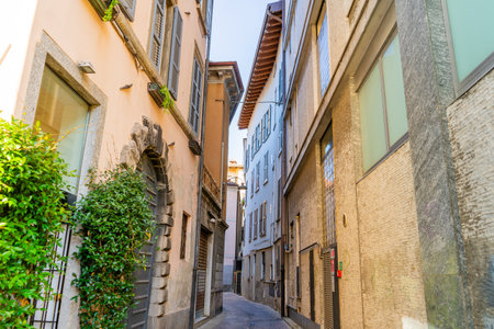 Paving stones empty narrow Italian street in Como city. Multicolor old house building architecture facadeの写真素材