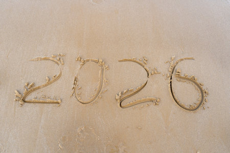 2025 numbers written in the sandy beach backgroundの写真素材