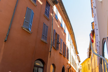 Narrow Italian street in Como city. Multicolor old house building architecture. Windows