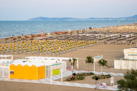Wide sandy beach with sun loungers and umbrellas view from above. Evening on Rimini Italy coast resortの写真素材
