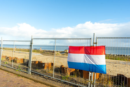 Dutch flag hangs on the fenceの写真素材