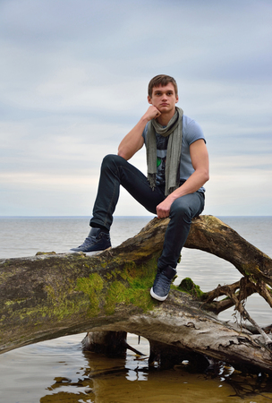 A young man in front of the sea の写真素材