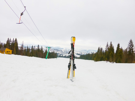 Skiing against the backdrop of the ski lift and the snow-capped mountains of the Carpathians. Beautiful scenery in the mountains in Transcarpathia, Ukraine.の写真素材