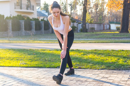 Young woman kneads before running at sunset