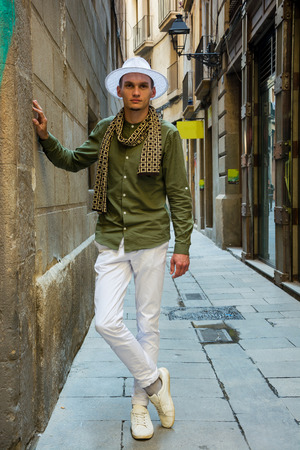 A young guy, a tourist in a hat on a narrow medieval street in the gothic quarter of Barcelona, Spainの写真素材