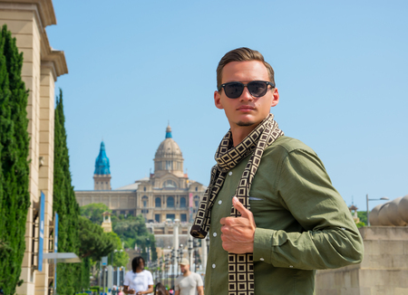 A young man, tourist standing near The National Palace, where the National Museum of Art of Catalonia, Barcelona, Spainのeditorial素材