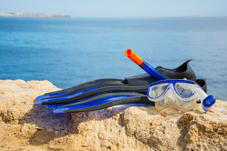 Mask with a snorkel tube and flippers on the background of the sea.の写真素材