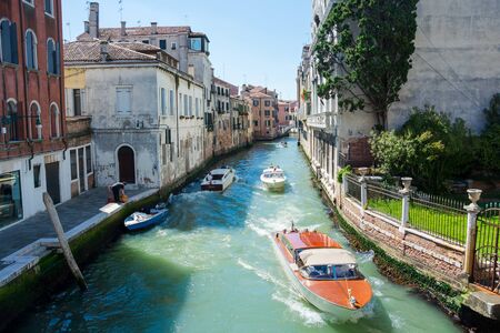 Editorial. June 2019. Venice, Italy. View of the city narrow street and canal in Venice on a sunny dayのeditorial素材