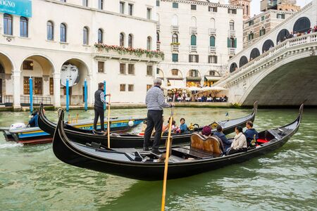 Editorial. May 2019. Venice, Italy. View of the Grand Canal and the Rialto Bridge in Venice. Gondoliers on gondolas near the Rialto Bridge at the views of Venice backgroundのeditorial素材