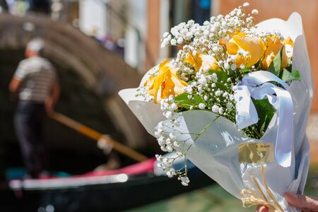 A bouquet of a orange roses at gondolier and Canal background in tne Venice, Italyの写真素材