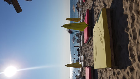 Odessa beach at sunset in Ukraine with yellow umbrellas, sun loungers and people relaxing on the Black Sea coastの写真素材