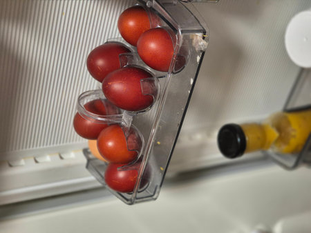 Chicken eggs, dyed brown for the Christian holiday of Easter, lie in a transparent container in the refrigeratorの写真素材