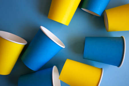 Yellow and blue paper cups on blue background. Set for party.の写真素材