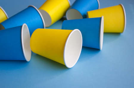 Yellow and blue paper cups on blue background. Set for party.の写真素材