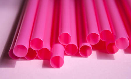Electric pink plastic straws on soft background. Set for party.の写真素材