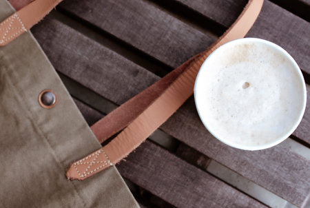 a cup of cappuccino and a tote bag