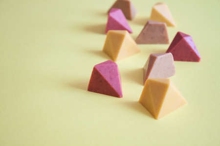 Colorful chocolate vegan pralines on yellow background.の写真素材