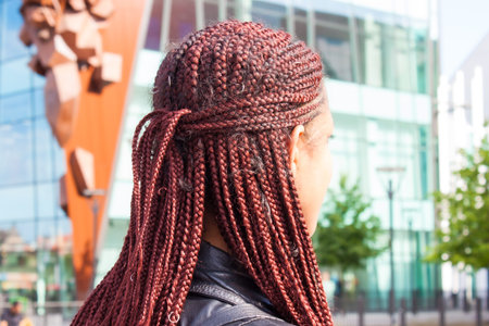 Girl with red braided hair style on street in summer.
