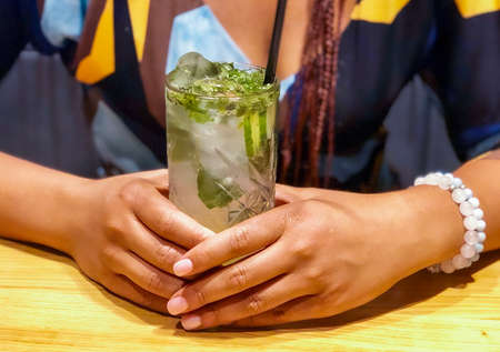 Girl's hands holding glass of fresh lemonade.の写真素材