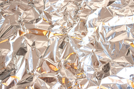 Abstract background made of textured silver aluminum foil. Backdrop for design.