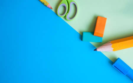 Colorful school supplies on green and blue background. Back to school, flat lay copy space concept.の写真素材