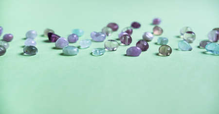 Colorful purple, lilac and green natural stones beads on trendy mint background.の写真素材