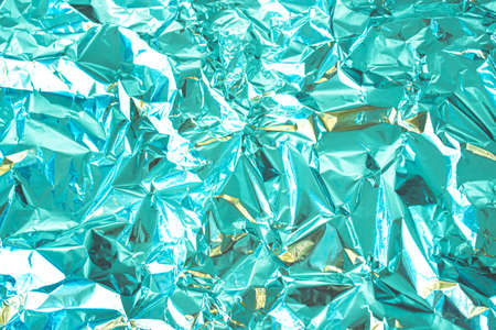 Abstract background made of textured mint azure toned aluminum foil. Backdrop for design.の写真素材