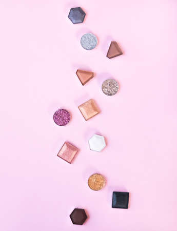 Colorful matte and glitter eye shadows pallet on light pink background. Top view, flat lay. Beauty concept.の写真素材