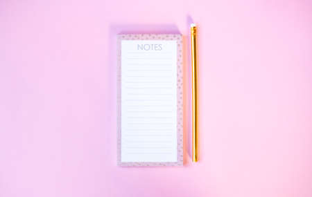 Notebook and cute golden pencils on gradient pink background. Flat lay style.の写真素材