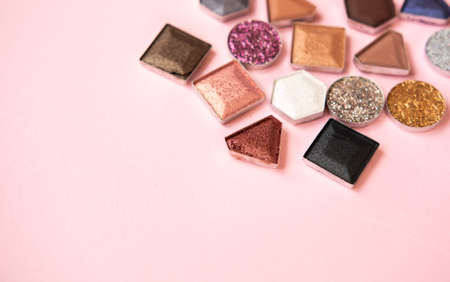 Colorful matte and glitter eye shadows pallet on light pink background. Top view, flat lay. Beauty concept.の写真素材