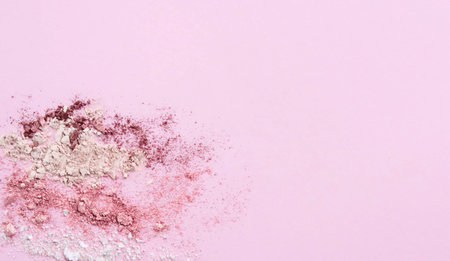 Smashed colorful eye shadows make up palette on light pink background. Beauty banner concept.