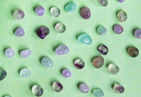 Colorful purple, lilac and green natural stones beads on trendy mint background.の写真素材