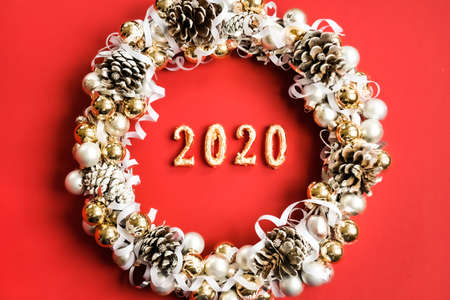 Golden 2020 and white, silver and golden wreath on trendy Christmas red background. Flat lay style.の写真素材