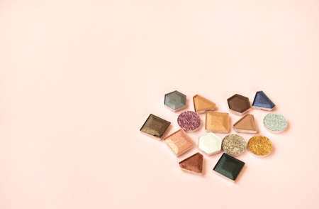 Colorful matte and glitter eye shadows pallet on pastel coral background. Top view, flat lay. Beauty concept.の写真素材
