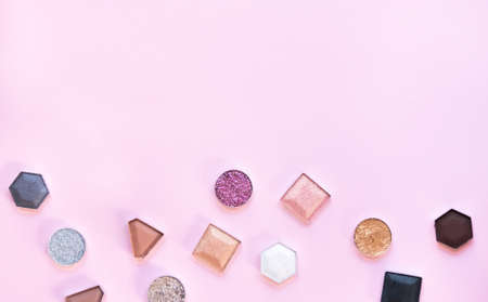 Colorful matte and glitter eye shadows pallet on light pink background. Top view, flat lay. Beauty concept.の写真素材