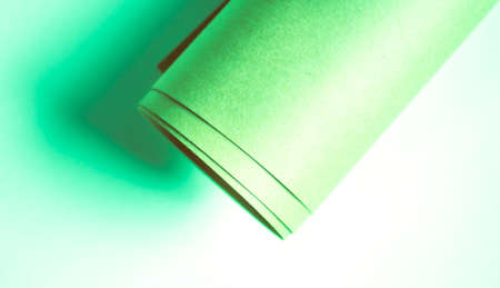 Kraft paper roll on white canvas toned in mint green color background.の写真素材