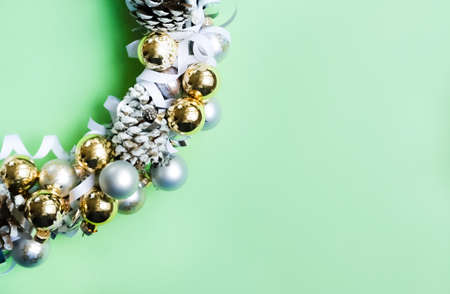 White, silver and golden ornaments Christmas wreath on trendy mint green background. Modern festive concept.の写真素材