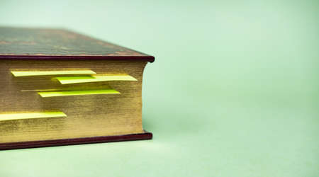 Book with golden pages and yellow bookmarks on bright trendy mint green background.の写真素材