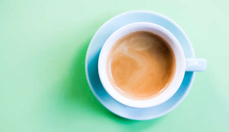 Mint blue cute cup of coffee on pastel green background. Lifestyle trendy minimalism concept.の写真素材