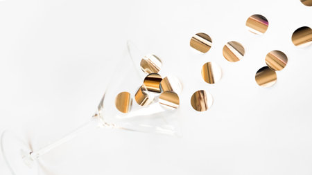 Martini glass with golden silver shiny confetti on white background. Party drink concept art....