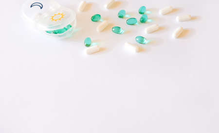 Pill case and mint green capsules on white background. Healthcare concept.の写真素材