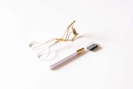 Cosmetic products, brow comb and eyelash curler on white background. Beauty concept.の写真素材