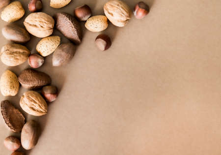 Different nuts on natural kraft paper background. Flat lay style. Healthy food concept.の写真素材