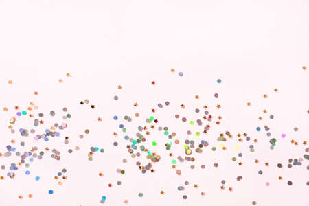 Golden stars and hologram glitter on pastel pink background. Festive holiday defocused backdrop.の写真素材