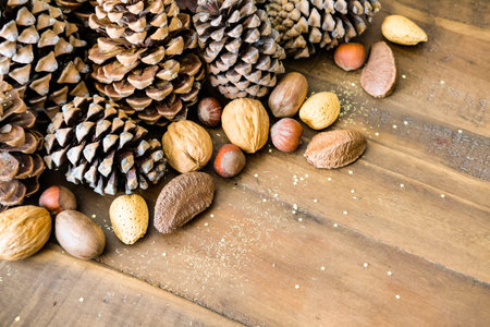 Christmas festive styled pine cones, nut mix and golden glitters background. Winter holidays...