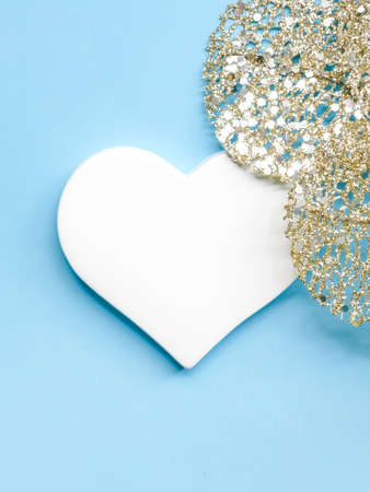 Silver decorations and white heart on pastel blue background. Winter holidays concept. の写真素材