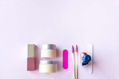 Assorted cosmetic products, cream, lipstick, nail file on pastel pink background. Beauty concept. Flat lay design.の写真素材